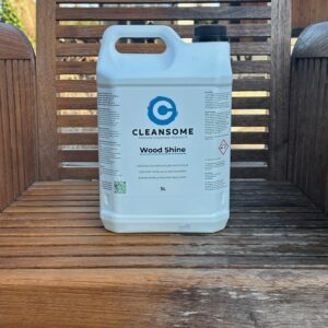 Fles Wood Shine op een teak houten stoel die voor de helft ontgrijst is.